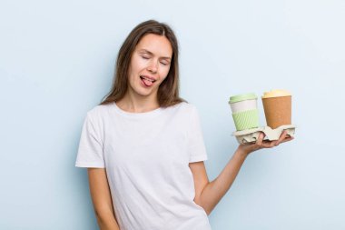 Neşeli ve asi tavırları olan genç bir kadın şaka yapıyor ve dilini dışarı çıkarıyor. kahve konseptini kaldır.