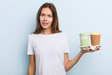 Genç yetişkin bir kadın mutlu ve hoş bir şekilde şaşırmış görünüyor. kahve konseptini kaldır.