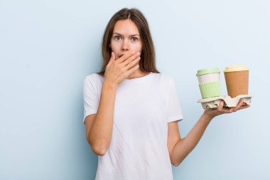 young adult woman covering mouth with hands with a shocked. take away coffee concept