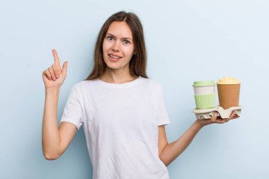 Genç yetişkin bir kadın bir fikri fark ettikten sonra mutlu ve heyecanlı bir dahi gibi hissediyor. kahve konseptini kaldır.