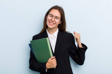 Genç bir kadın şokta, gülüyor ve başarıyı kutluyor. Üniversite öğrencisi konsepti