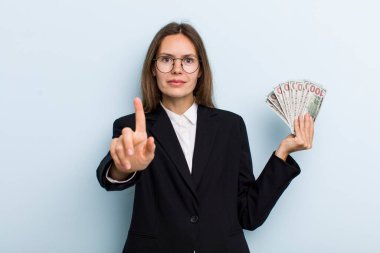 Genç yetişkin kadın gururla gülümsüyor ve kendinden emin bir numara oluyor. Dolar banknotları konsepti