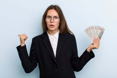 İnançsızlığa şaşırmış genç bir kadın. Dolar banknotları konsepti