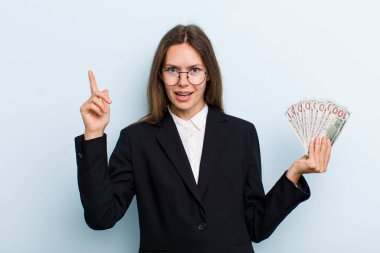 Genç yetişkin bir kadın bir fikri fark ettikten sonra mutlu ve heyecanlı bir dahi gibi hissediyor. Dolar banknotları konsepti