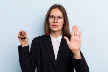 Genç bir kadın ciddi görünüyor. Avuç içini gösteriyor. Durdurma hareketi yapıyor. Bitcoin konsepti