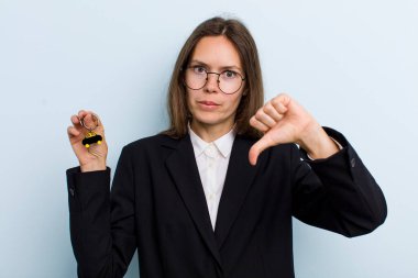 Genç yetişkin bir kadın kendini kötü hissediyor, baş parmağını kaldırıyor. Bitcoin konsepti