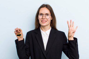 Genç yetişkin kadın gülümsüyor ve arkadaş canlısı görünüyor, dört numarayı gösteriyor. Bitcoin konsepti