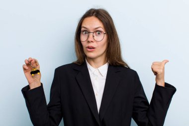 İnançsızlığa şaşırmış genç bir kadın. Bitcoin konsepti