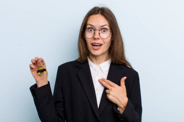 Şok olmuş ve ağzı açık, kendini işaret eden genç bir kadın. Bitcoin konsepti