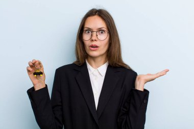 Genç bir kadın şaşırmış ve şok olmuş görünüyor. Çenesi düşmüş ve elinde bir nesne tutuyor. Bitcoin konsepti