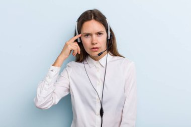 young adult woman feeling confused and puzzled, showing you are insane. telemarketer concept