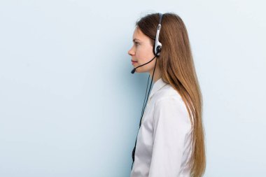 young adult woman on profile view thinking, imagining or daydreaming. telemarketer concept