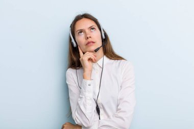 young adult woman thinking, feeling doubtful and confused. telemarketer concept