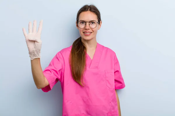 Young Adult Woman Smiling Looking Friendly Showing Number Four Nurse — Stockfoto