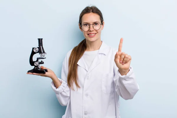 Young Adult Woman Smiling Proudly Confidently Making Number One Scientist — Stockfoto