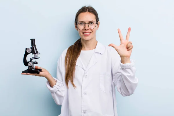 여성이 웃으며 보이고 위입니다 현미경을 과학자 — 스톡 사진