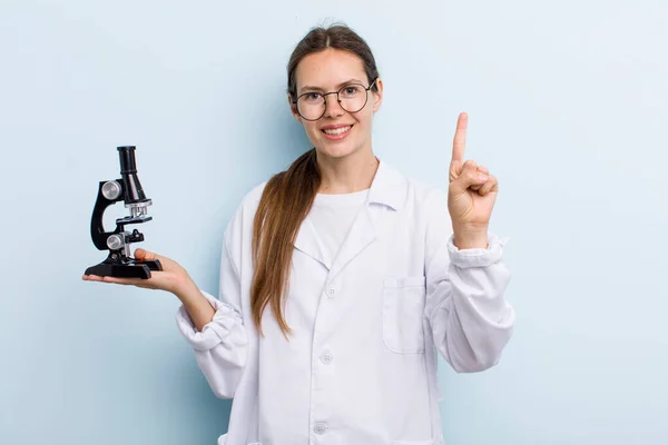 Young Adult Woman Smiling Looking Friendly Showing Number One Scientist — Stockfoto