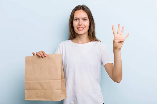 Young Adult Woman Smiling Looking Friendly Showing Number Four Delivery —  Fotos de Stock