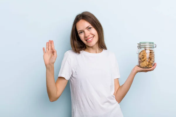 Young Adult Woman Smiling Happily Waving Hand Welcoming Greeting You — Stock fotografie