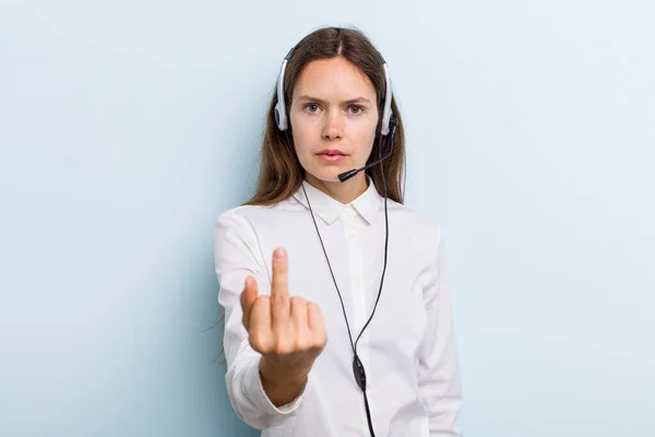 young adult woman feeling angry, annoyed, rebellious and aggressive. telemarketer concept