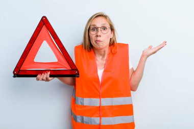 Sarışın, genç, yetişkin bir kadın şaşkın, şaşkın ve şüpheci hissediyor. araba acil durumu