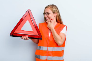 Mutlu, kendinden emin, elleri çenesinde gülümseyen genç sarışın bir kadın. araba acil durumu