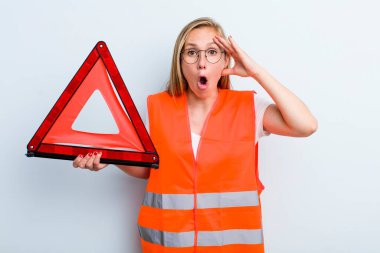 Sarışın, genç, yetişkin bir kadın mutlu, şaşkın ve şaşırmış görünüyor. araba acil durumu