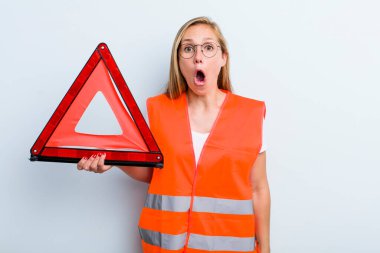 Sarışın, genç, yetişkin bir kadın çok şaşırmış ya da şaşkın görünüyor. araba acil durumu