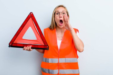 Sarışın, genç, yetişkin bir kadın kendini mutlu hissediyordu. Elleri ağzının kenarında bağırıyordu. araba acil durumu