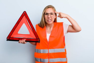 Sarışın, genç, yetişkin bir kadın. Kafası karışık ve şaşkın hissediyor. Deli olduğunu gösteriyor. araba acil durumu