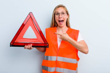 Sarışın, genç, yetişkin bir kadın heyecanlı ve şaşırmış görünüyor. araba acil durumu