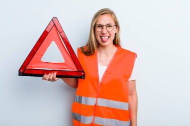 Sarışın, genç, yetişkin bir kadın. Tiksinmiş ve sinirlenmiş hissediyor. Dilini çıkarıyor. araba acil durumu