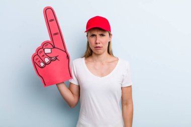 blonde young adult woman feeling puzzled and confused. number one fan concept