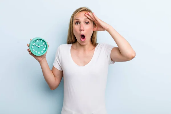 Blonde Young Adult Woman Looking Happy Astonished Surprised Alarm Clock —  Fotos de Stock