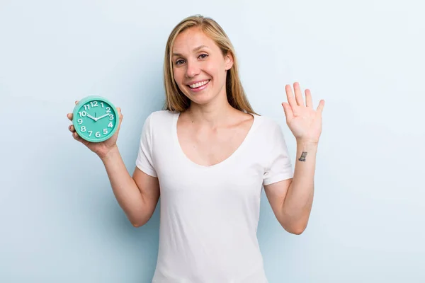Blonde Young Adult Woman Smiling Happily Waving Hand Welcoming Greeting — Foto de Stock