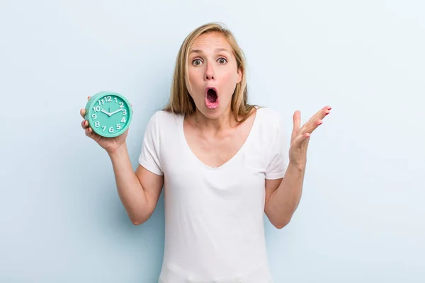 Blonde Young Adult Woman Feeling Extremely Shocked Surprised Alarm Clock — Stockfoto