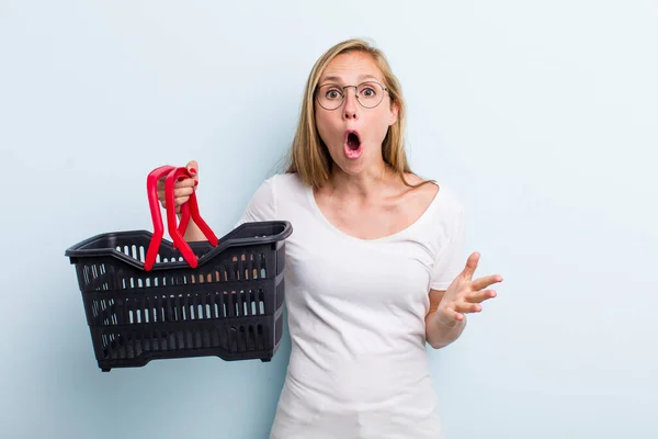 Blonde Young Adult Woman Feeling Extremely Shocked Surprised Shopping Basket — ストック写真