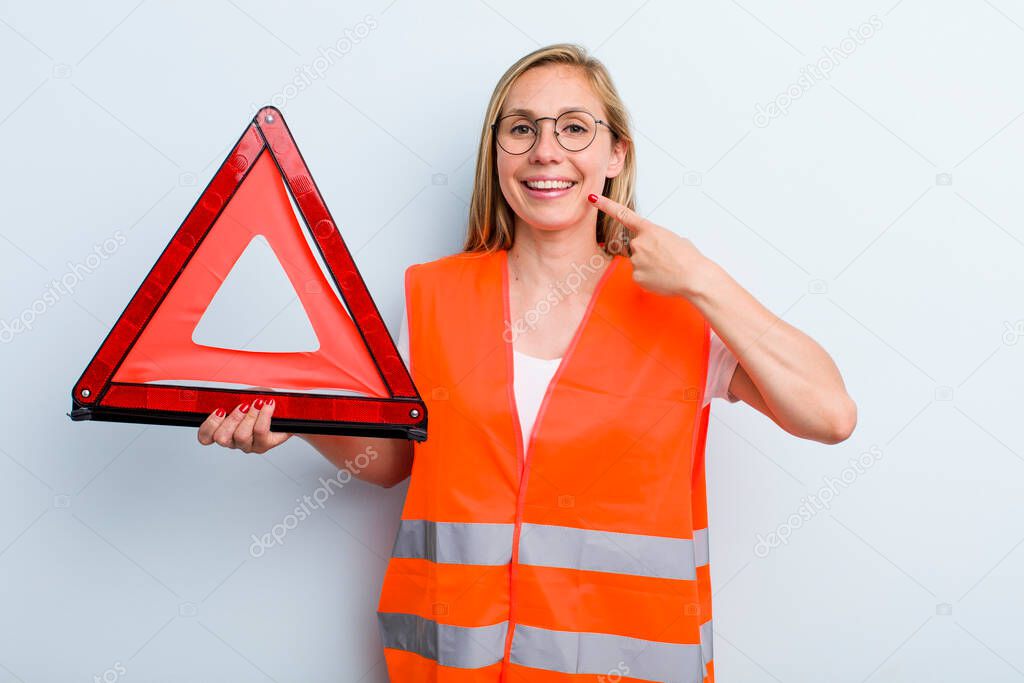 blonde young adult woman smiling confidently pointing to own broad smile. car emergency