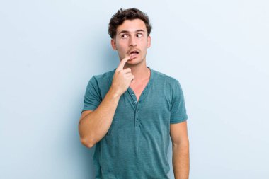 Şaşırmış, gergin, endişeli ya da korkmuş bakışları olan genç yakışıklı bir adam kopya boşluğuna bakıyor.