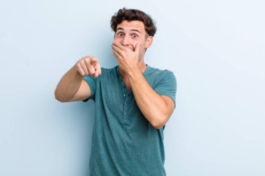 Genç yakışıklı adam sana gülüyor, kamerayı işaret ediyor ve seninle dalga geçiyor ya da alay ediyor.