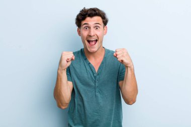 Genç yakışıklı adam şok olmuş, heyecanlı ve mutlu, gülüyor ve başarıyı kutluyor, vay canına diyor.!