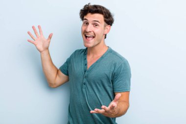 Genç yakışıklı adam mutlu, kibirli, gururlu ve kendini beğenmiş, kendini bir numara gibi hisseden