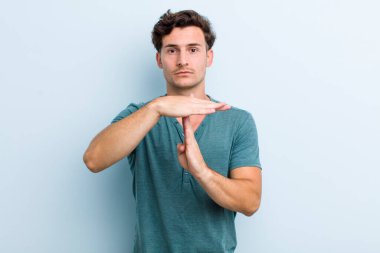 Genç yakışıklı adam ciddi, sert, kızgın ve canı sıkkın görünüyor.