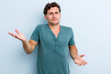 Şaşkın, şaşkın ve stresli görünen genç bir adam. Farklı seçenekler arasında merak ediyor. Belirsiz hissediyor.