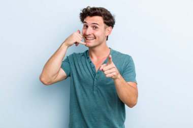 Genç yakışıklı adam neşeyle gülümsüyor ve kamerayı işaret ediyor. Sonra seni arıyor, telefonla konuşuyor.