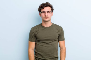 Genç, yakışıklı bir adam üzgün, üzgün ya da kızgın ve olumsuz bir tavırla, anlaşmazlık içinde somurtuyor.