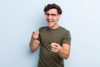 Genç yakışıklı adam kendini mutlu, havalı, tatmin olmuş, rahat ve başarılı hissediyor, kameraya bakıyor, seni seçiyor.