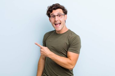 Genç ve yakışıklı bir adam heyecanlı ve şaşırmış görünüyor.