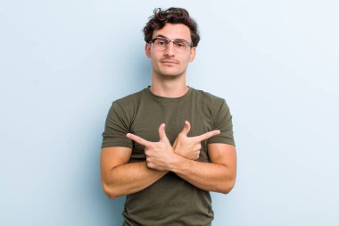 Şaşkın, kafası karışmış, güvensiz ve şüpheyle zıt yönlere bakan genç yakışıklı bir adam.