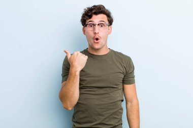 Genç ve yakışıklı adam inançsızlıktan şaşkın şaşkın bakıyor, yan taraftaki objeyi işaret ediyor ve diyor ki vay canına, inanılmaz.